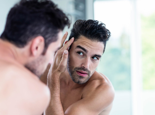 man staring in mirror