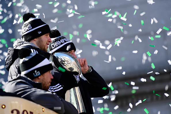 PHILADELPHIA, PA - FEBRUARY 08: (L-R) Quarterbacks Nick Foles #9, Nate Sudfeld #7 and Carson Wentz #11 of the Philadelphia Eagles, acknowledge fans as Sudfeld hoists the Vince Lombardi Trophy atop a parade bus during festivities on February 8, 2018 in Philadelphia, Pennsylvania. The city celebrated the Philadelphia Eagles' Super Bowl LII championship with a victory parade. (Photo by Corey Perrine/Getty Images)