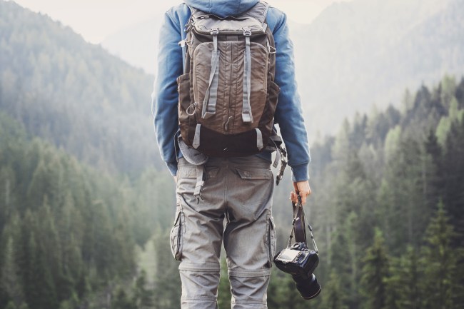 Young man photographer holding photo camera