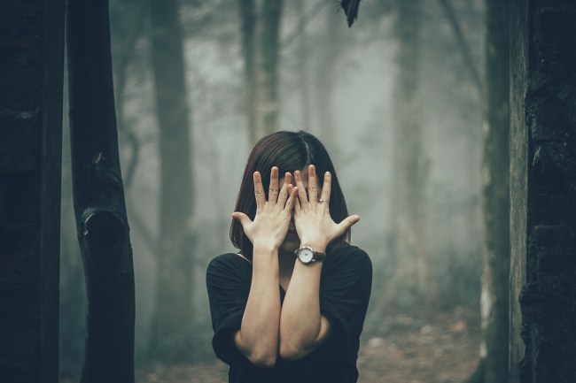 woman covering eyes and face with hands
