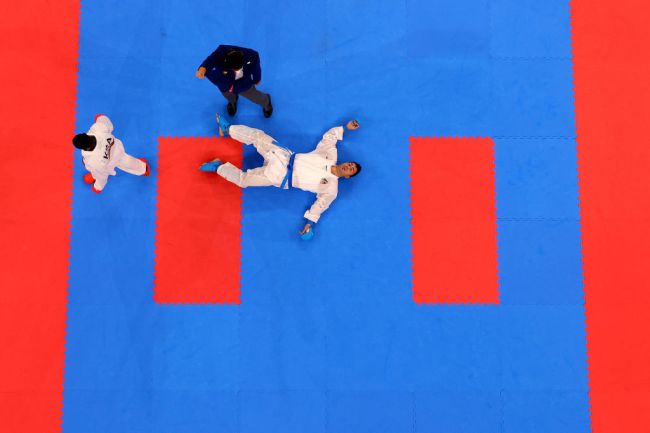 TOKYO, JAPAN - AUGUST 07: Sajad Ganjzadeh (R) of Team Iran lays on the tatami after being struck by Tareg Hamedi of Team Saudi Arabia during the Men’s Karate Kumite +75kg Gold Medal Bout on day fifteen of the Tokyo 2020 Olympic Games at Nippon Budokan on August 07, 2021 in Tokyo, Japan. 