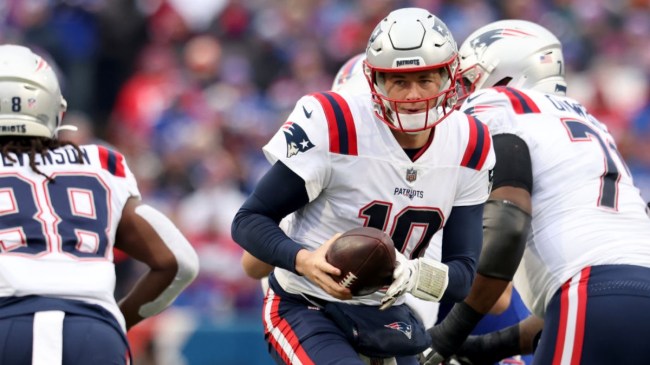 New England Patriots quarterback Mac Jones handing the ball off