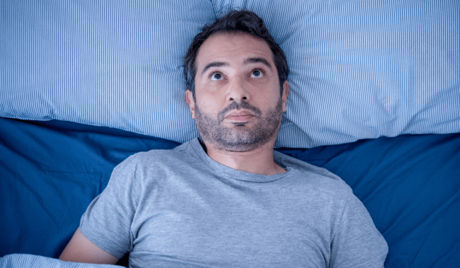 man in bed cant sleep