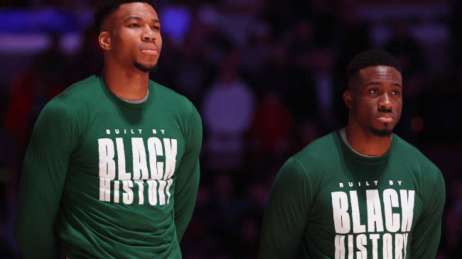 Thanasis and Giannis Antetokounmpo stand before a Bucks game.