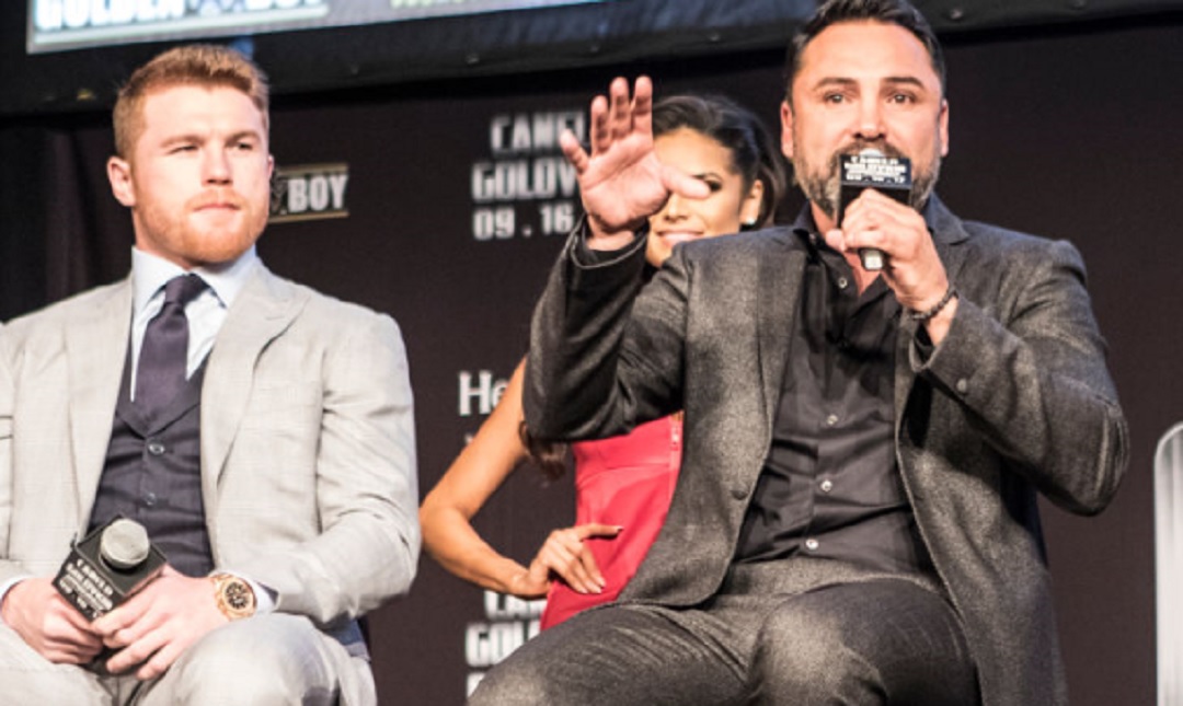 Canelo Alvarez sitting next to Oscar De La Hoya