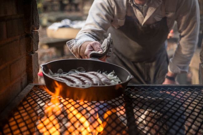 Smithey Cast Iron Skillet cooking sausage on a fire pit