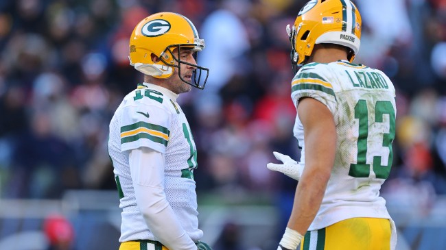 Aaron Rodgers talks to teammate Allen Lazard on the field.