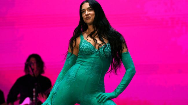 dua lipa in a green outfit performing on stage