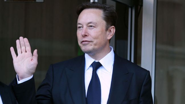 elon musk waving in a black suit