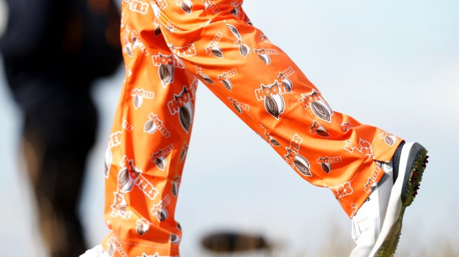 John Daly walks the golf course while sporting his custom Hooter's pants.
