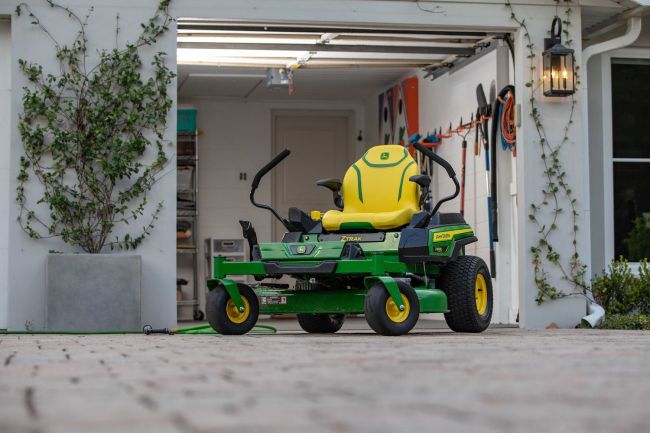 The John Deere Electric ZTrak Zero Turn mower parked outside a home garage