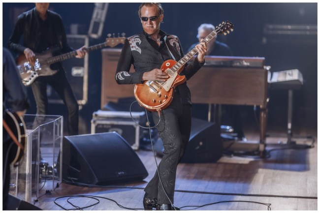 Joe Bonamassa playing guitar in concert on a stage