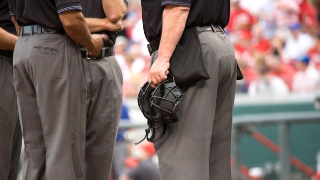 A group of umpires huddle on the field.
