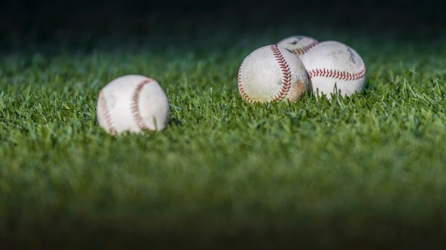 A group of baseballs in the outfield grass.