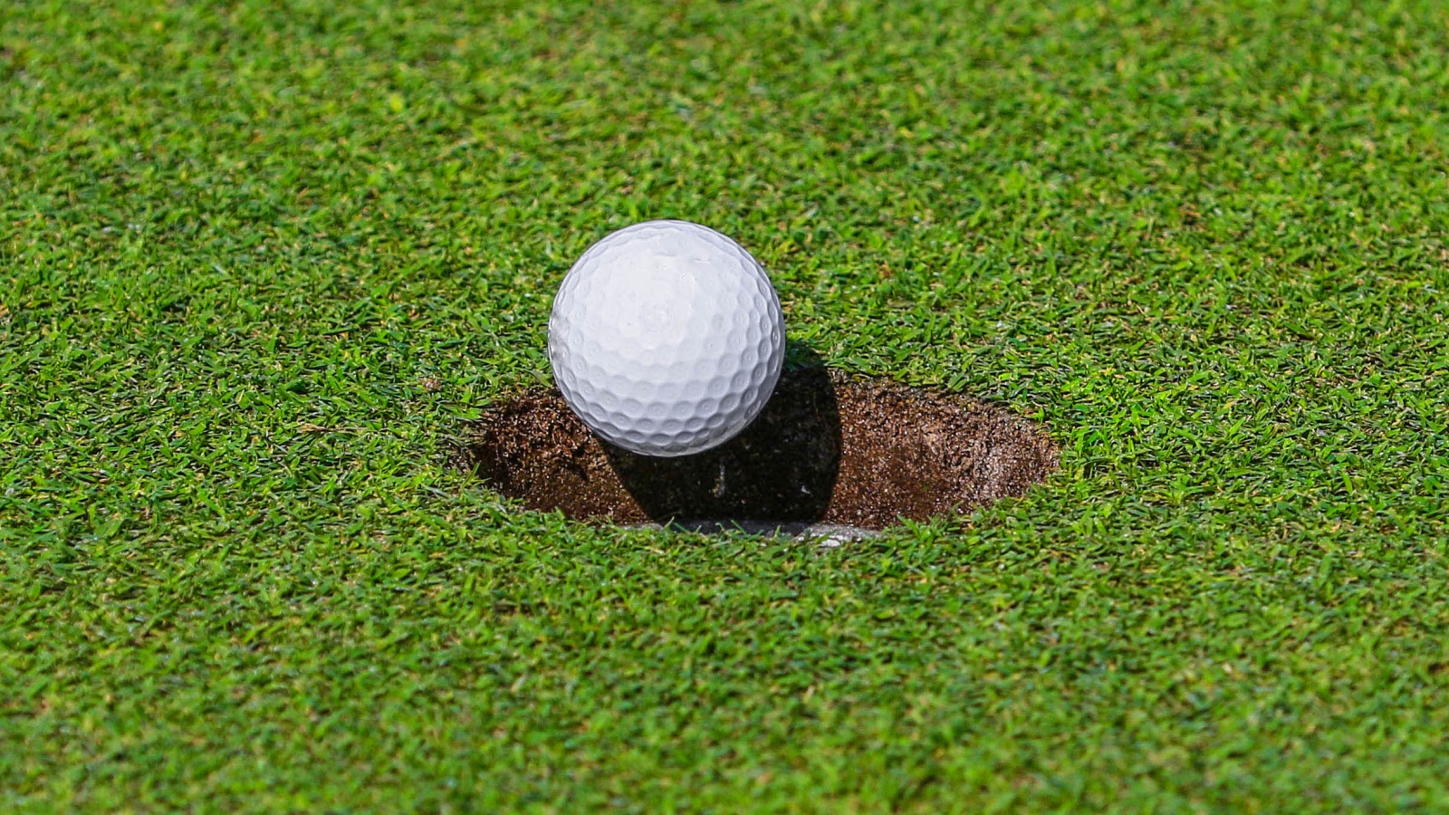 golf ball rolling into a hole