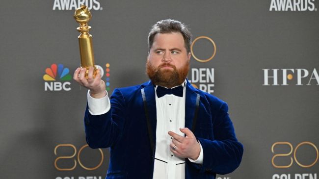 Paul walter hauser holding a golden globe award