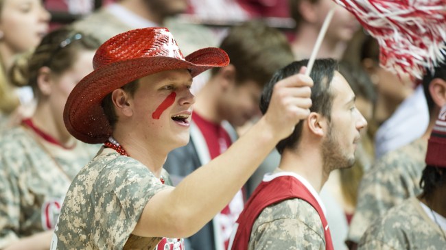 An Alabama basketball fan waves a pom pom in the crowd.