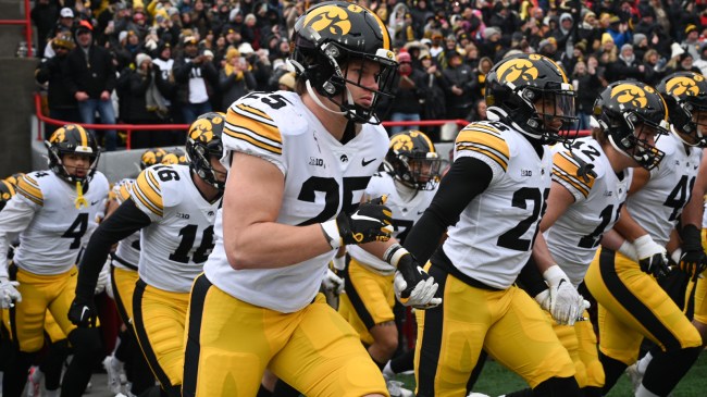The Iowa football team runs onto the field.