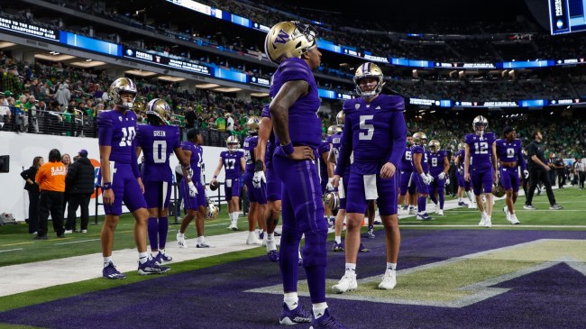 Michael Penix stands in the endzone with teammates before a Washington football game.