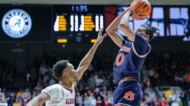 An Auburn player shoots over an Alabama defender.