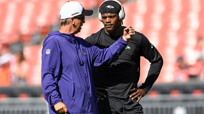 Ravens OC Todd Monken talks to QB Lamar Jackson before a game.