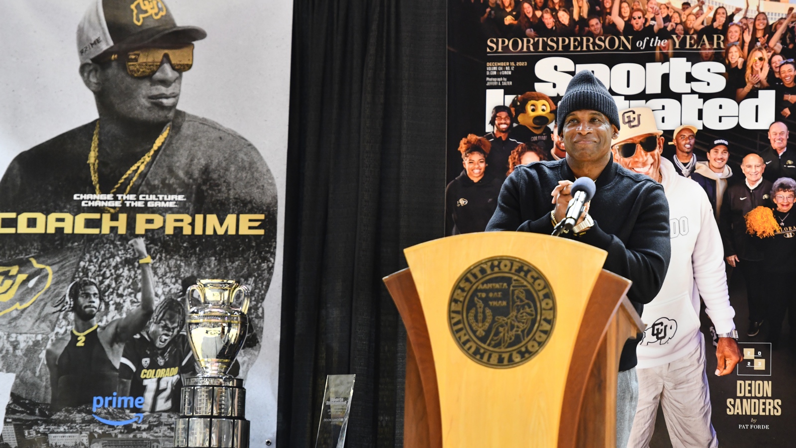 Deion Sanders poses at the podium