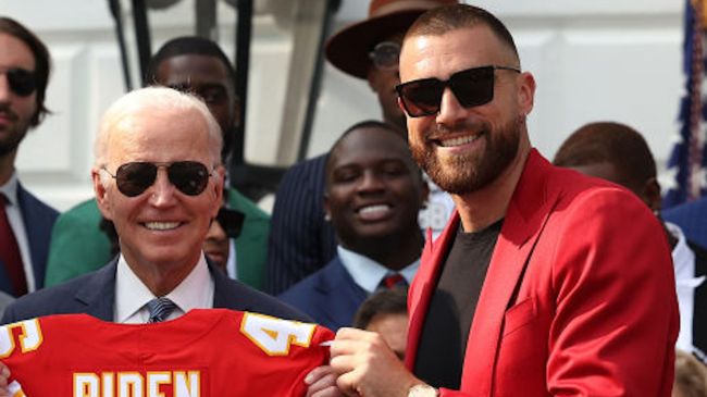 travis kelce and joe biden holding up a jersey
