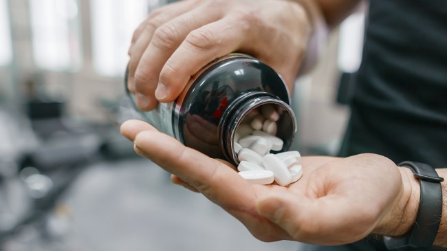 man taking pills in gym