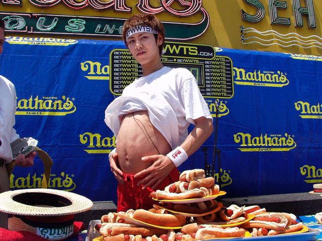 All-time world record holder Takeru Kobayashi of Japan, who ate 50 hot dogs and buns in 12 minutes in 2001, breaks his own record in 2002 by eating 50 1/2 hot dogs and buns. (Photo by Mychal Watts/WireImage)