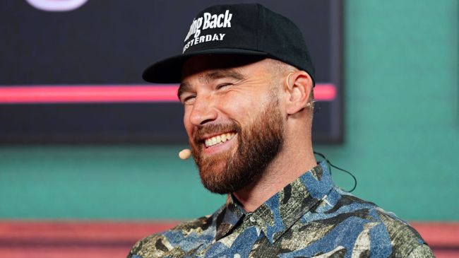 travis kelce smiling on stage