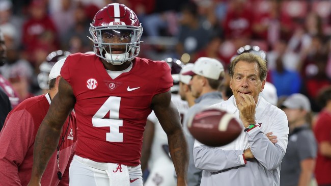 Alabama QB Jalen Milroe on the field as coach Nick Saban watches on.