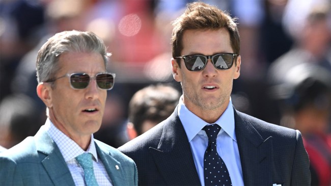 Broadcasters Kevin Burkhardt and Tom Brady walk along the field before game