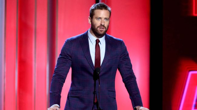 armie hammer wearing a suit speaking into a mic