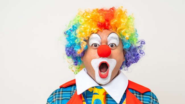 Clown man in colorful costume wearing wig