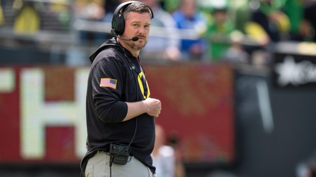 Oregon football coach Dan Lanning walks onto the field.