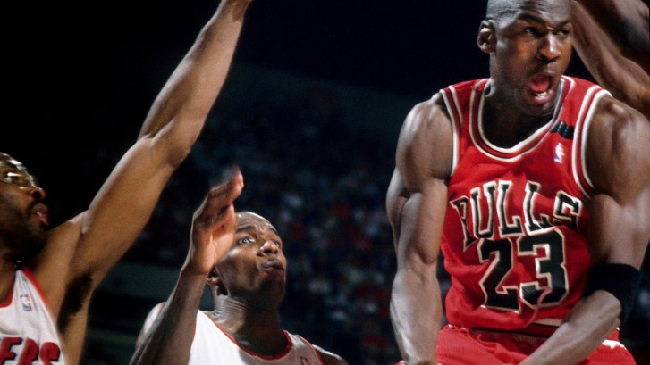 Michael Jordan scoring amid triple coverage from defense