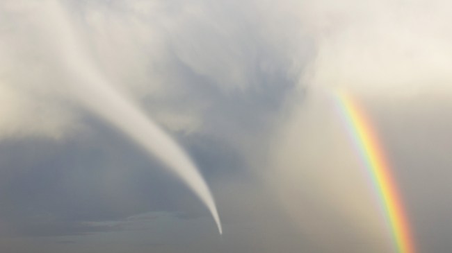 A rainbow next to a tornado