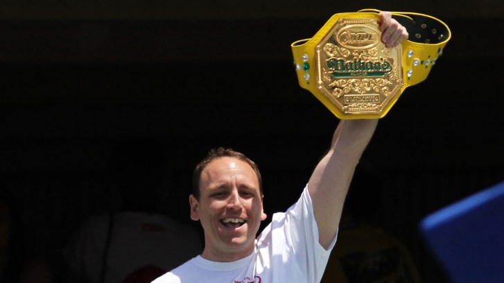 Joey Chestnut raising his championship belt